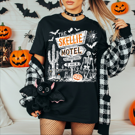 Person wearing a black Halloween-themed sweatshirt with graphics, holding a plush bat toy.